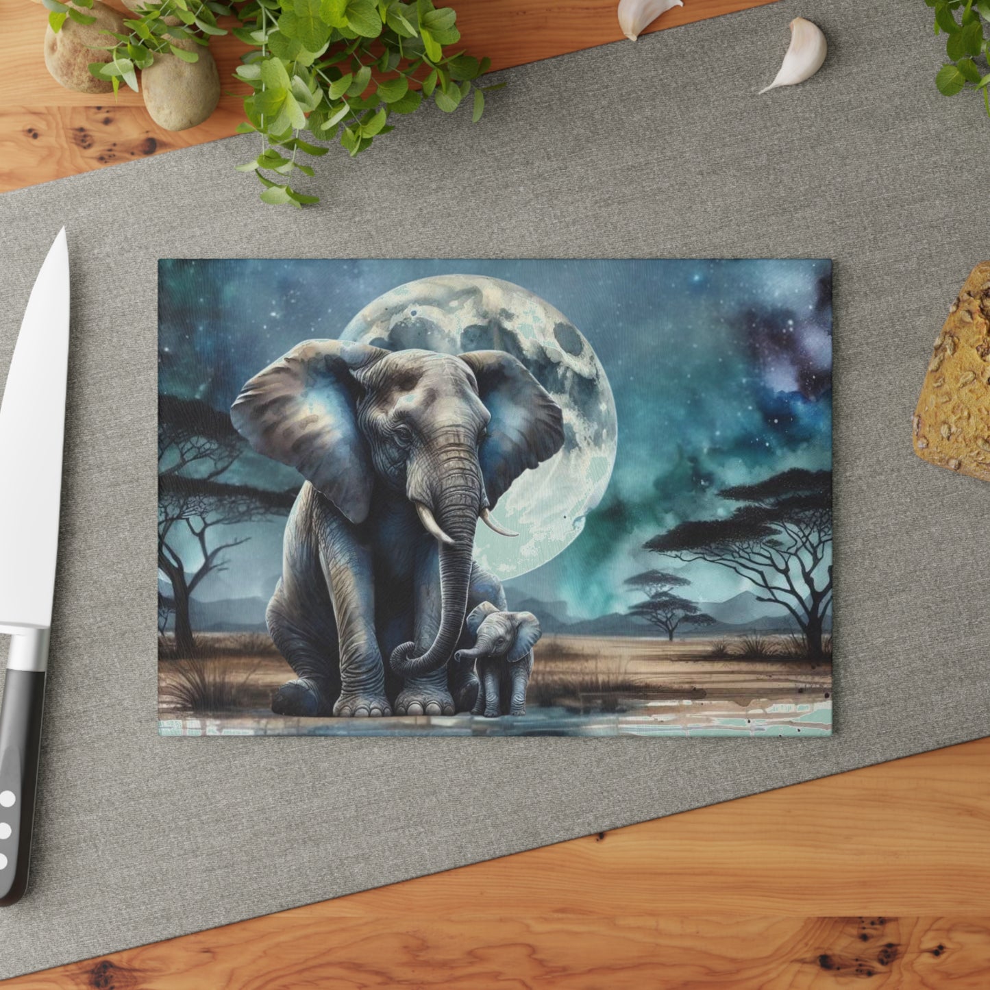 Tabla de cortar de vidrio con forma de mamá y bebé elefante, con una luna llena brillante detrás de ellos