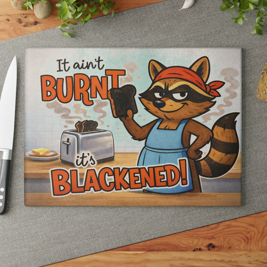 It Ain’t Burnt, It’s Blackened Glass Cutting Board – Sassy Raccoon Kitchen Art with Attitude